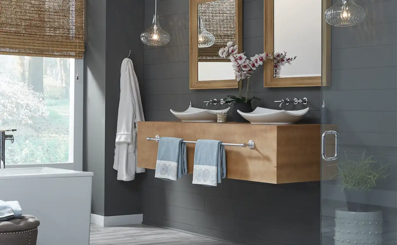 Bathroom scene with grey walls and wood sink and cabinet. 